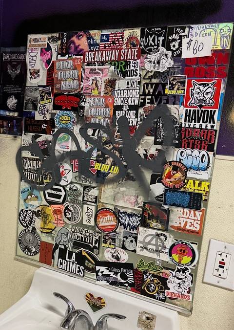 Sticker-bombed bathroom mirror