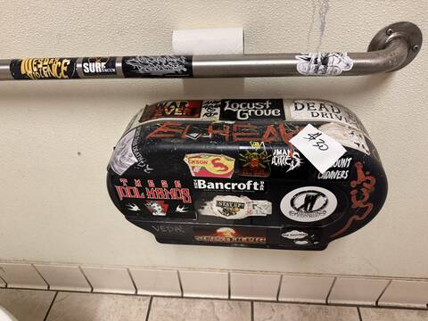 Black touchless towel dispenser, sticker-bombed